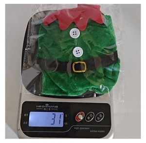 Elf style wine bottle cover on a scale showing 31g weight for Christmas decor