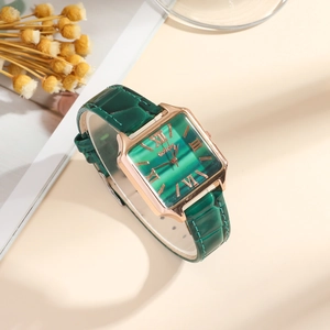 Detail of vintage emerald square dial watch with gold hands and green leather strap