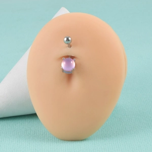 Macro detail of 14G stainless steel navel ring with pink cat eye stone in 4-claw setting