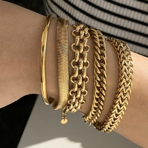 Gold stainless steel bracelet set with various link patterns worn on model's wrist