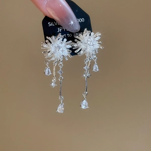 Detail view of silver starburst earrings with pearls and zircon water drop tassels