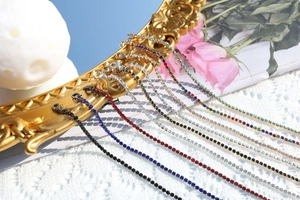 Artistic close-up of vibrant rhinestone necklaces in various colors on a vintage gold frame