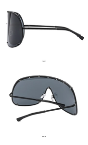 Detail view of large brown one-piece sunglasses with silver metal rivets on the side and back