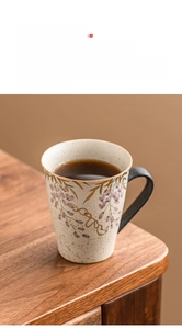 Macro shot of a textured ceramic mug featuring purple floral patterns and a wide dark handle