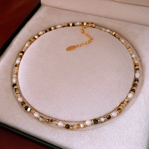 Detailed close-up of baroque pearls and mixed gemstones on a luxury beaded necklace