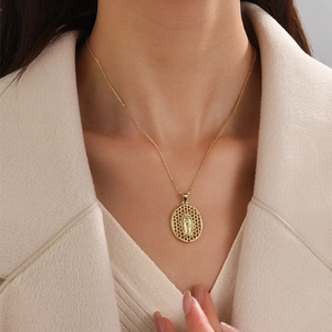Close-up of a gold-plated oval Virgin Mary pendant with cubic zirconia on a model
