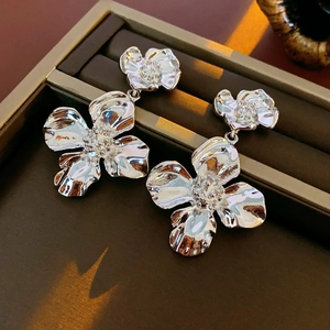 Macro shot of silver metallic double-layered flower earrings in a premium jewelry box