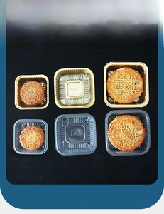 Macro detail of 7.5cm clear and gold PET plastic mooncake trays with square rounded edges