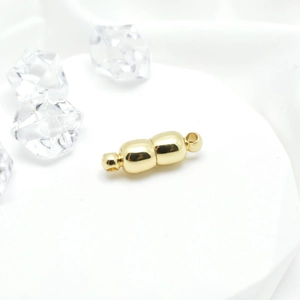 Polished gold magnetic clasp for DIY necklaces and bracelets on white satin background