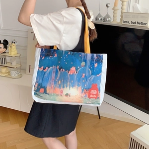 Détail d'un sac fourre-tout en toile blanche avec imprimé dessin animé et anses jaunes