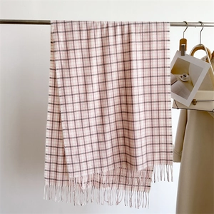 Close-up of pink and grey checkered cashmere-feel scarf with delicate fringe tassels