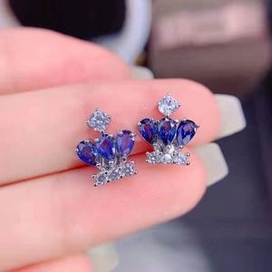 Detail of crown-shaped stud earrings featuring blue teardrop stones and white cubic zirconia