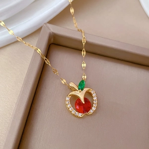 Close-up of luxury apple-shaped pendant with red gemstone and sparkling zircons