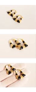 Detailed view of black enamel trapezoid earrings with vintage wrinkled gold texture