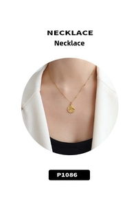 Détail d'un collier en or 18k avec pendentif rond texturé sur une fine chaîne perlée