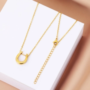 Detail of gold U-shaped pendant and adjustable extension chain with lobster clasp