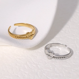 Elegant gold and silver bow heart double-layered open rings on a white textured background