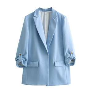 Detail of light blue blazer showing notched lapel and gathered cuffs with buckle straps