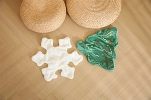Detailed texture of snowflake and Christmas tree plush pillow skins on wooden floor