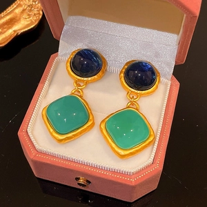 Retro Goldene Tropfenohrringe mit blauen und grünen Steinen in einer Schmuckschatulle
