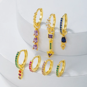 Détail d'un ensemble de sept boucles d'oreilles dorées avec zircons de couleur sur socles