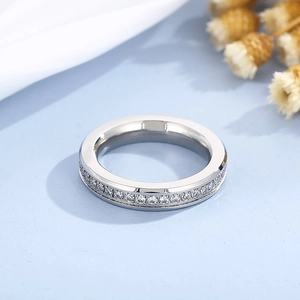 Macro shot of silver eternity ring with full cubic zirconia stones on blue fabric