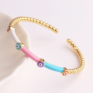 Close-up of golden Evil Eye open bangle with colorful enamel sections and bamboo pattern