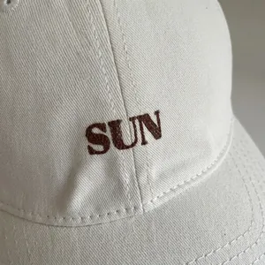 Minimalist beige cotton baseball cap with premium brown sun embroidery detail
