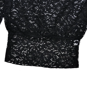 Détail rapproché du tissu en dentelle noire avec motifs floraux et texture ajourée