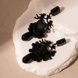 Gros plan détaillé de boucles d'oreilles vintage cœur noir et perles avec cristaux