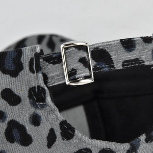 Detail shot of the leopard print corduroy baseball cap with a silver metal buckle