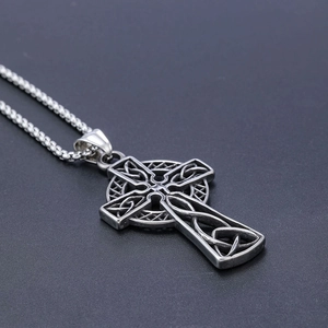 Macro shot of Celtic cross pendant showing intricate knot carvings and silver finish