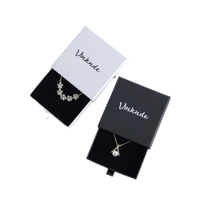 Elegant black and white drawer jewelry boxes with floral and pearl necklaces
