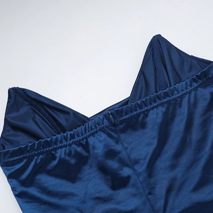 Detail view of the hidden back zipper and elastic pleated waist on the dark blue satin dress