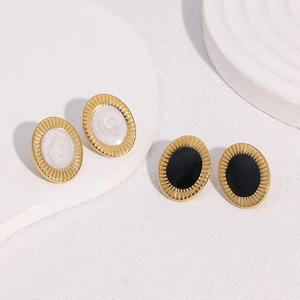 Nahaufnahme von Vintage 18k vergoldeten Ohrsteckern mit schwarzer und weißer Emaille