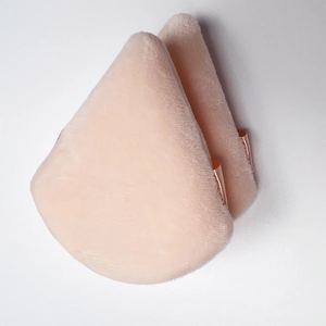 Detailed view of two pink velvet triangle powder puffs with elegant gold finger straps