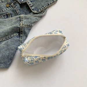 Quilted floral makeup bag with blue flower pattern showing open beige zipper
