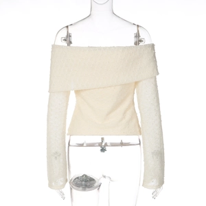 Close-up of off-white off-shoulder top showing fine dotted texture and flared sleeves