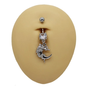 Détail macro du piercing de nombril dragon et lune argenté avec zircon blanc brillant