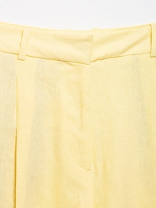 Detailed macro view of light yellow cotton-linen fabric texture and waist stitching