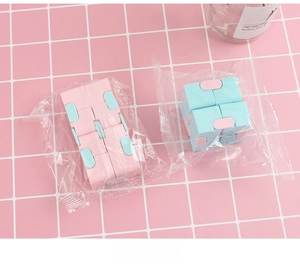 Macro detail of infinity cube fidget toys in pink and blue with OPP bag packaging
