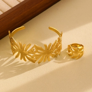 Detail shot of gold-plated palm leaf jewelry set featuring textured cuff and ring