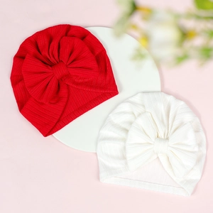 Close-up of baby turban hats in red and white colors featuring large rib knit bows