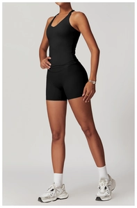 Dettaglio del set da yoga nero con scollo a V e pantaloncini a compressione sulla modella