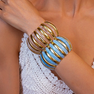 Detail of wide resin beaded bracelets in blue and pink with gold foil accents