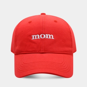 Close-up of white 'mom' embroidery on a red cotton baseball cap with reinforced stitching