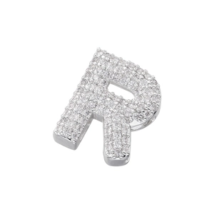 Macro shot of a silver letter R pendant featuring micro-pave clear cubic zirconia stones