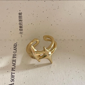 Macro detail of adjustable gold star ring on minimalist textured card background