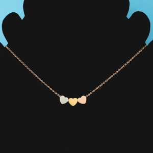 Detailed view of tricolor heart pendants in gold, silver, and rose gold on a fine chain