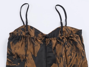 Vue détaillée du tissu jacquard noir et or avec bretelles réglables et fermeture éclair